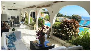 a living room with a view of a pool at Mahina's Lodge in Mahina