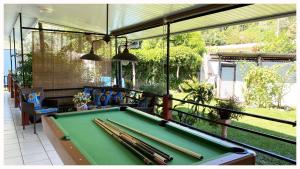 a pool table with cue bats on a patio at Mahina's Lodge in Mahina