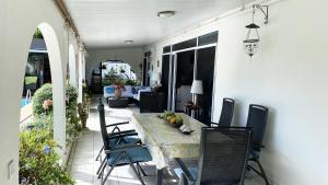 a dining table and chairs on a patio at Mahina's Lodge in Mahina