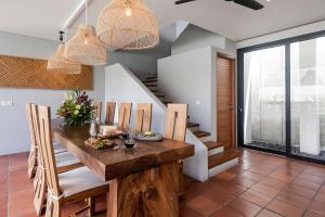 a dining room with a wooden table and chairs at Villa Tamara Canggu Bali in Kerobokan