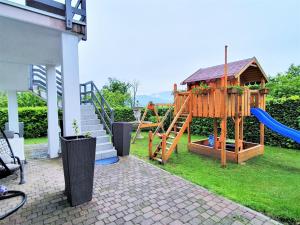 un parque infantil con tobogán y una casa de juegos en Welcoming holiday home in Germignaga VA with garden, en Brissago Valtravaglia