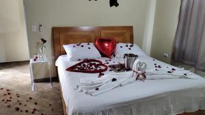 1 cama con sábanas blancas y almohada roja en RECANTO NA MATA, en Morretes