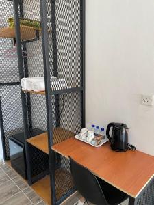 a table with a tea kettle on it next to a shelf at Kedawang Village Langkawi in Pantai Cenang