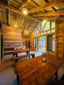 a large room with wooden tables in a cabin at Casa del Árbol - Glamping in Malalcahuello