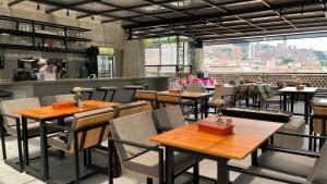 a restaurant with wooden tables and chairs and a bar at Edificio Helena in Medellín