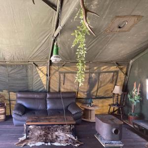 a living room with a couch in a tent at Pre Hub Tokachi 