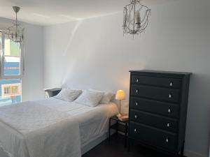 a bedroom with a bed and a black dresser at Sweet Laguna Home with FREE PARKING in Las Lagunas
