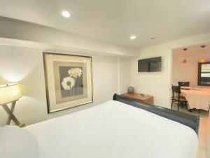 a bedroom with a white bed and a table with a chair at COMFY 3 Bdrm Basement Home in Washington, D.C.