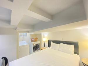 een slaapkamer met een bed en een wasmachine bij COMFY Basement Home 2 Bdrm1Den 3Queen Beds in Washington