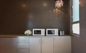 a kitchen with two microwaves on top of a counter at Cosmo Hotel Hong Kong in Hong Kong