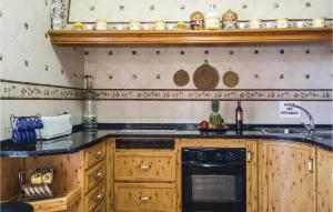 a kitchen with wooden cabinets and a stove top oven at Amazing Home In Olvera With 4 Bedrooms, Wifi And Outdoor Swimming Pool in Olvera