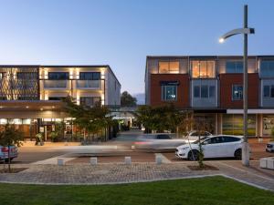 a parking lot with cars parked in front of buildings at Porters Boutique Hotel in Havelock North