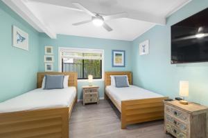 Duas camas num quarto com paredes azuis em Pandanus On Emerald em Emerald Beach