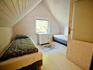 a bedroom with a bed and a window in a attic at Comfortable, two-story holiday houses for 5 people, Pobierowo in Pobierowo