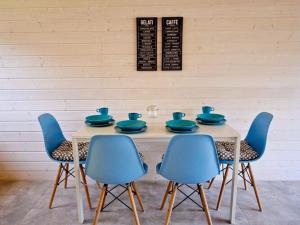 - une table avec 4 chaises et des plats bleus dans l'établissement Comfortable, two-story holiday houses for 5 people, Pobierowo, à Pobierowo