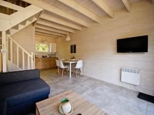 a living room with a couch and a tv on a wall at Comfortable, two-story holiday houses for 6 people, Pobierowo in Pobierowo