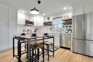 a kitchen with a table and chairs and a refrigerator at Hawksbill Home~Hot Tub~Dog Friendly~Modern~Water Front Porch in Luray