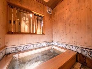 Tsuruya / Vacation STAY 59065 في Miyaji: حوض استحمام ساخن في غرفة مع نافذة