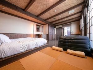 Tsuruya / Vacation STAY 59065 في Miyaji: غرفة نوم بسرير كبير وكرسي جلدي