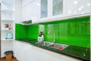 a kitchen with green and white cabinets and a sink at Homestay Hạ Long 3 phòng ngủ view biển in Ha Long
