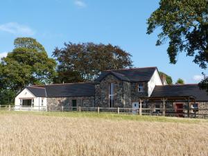 a stone house with a black roof at Dunamoy Cottages & Spa in Ballyclare