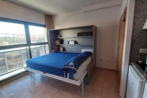 プラヤ・デアロにあるMini-apartament cèntric a Platja d'Aroのベッドと大きな窓のある寝室