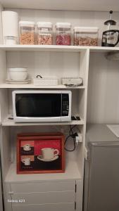 a kitchen shelf with a microwave and a box at 66 Chaucer B&B with Complimentary Breakfast to Go Bag in Cambridge