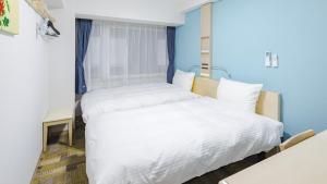 two beds in a room with blue walls at Toyoko Inn Kyoto Nijojo Minami in Kyoto