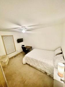亞特蘭大的住宿－In city living，一间卧室配有一张床、一张桌子和吊扇