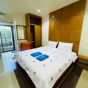 a bedroom with a large bed with blue pillows on it at ดาระณี เพลส in Udon Thani