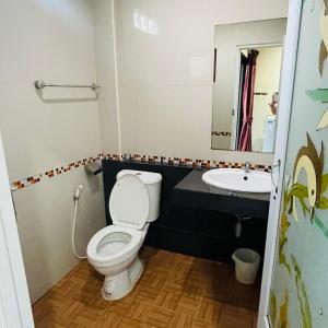 a bathroom with a toilet and a sink at ดาระณี เพลส in Udon Thani