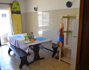a kitchen with a table and a surfboard on the wall at Surf House Peniche in Baleal