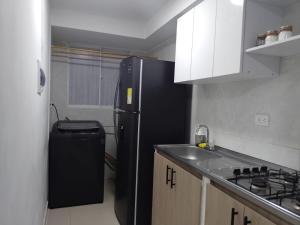 a kitchen with a black refrigerator and a sink at Apto 3 habit +2TV-Wifi, Netflix-Parqueadero gratis in Barranquilla +12 photos
