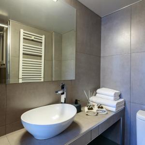 een badkamer met een grote witte wastafel en een spiegel bij Armoniko in Athene