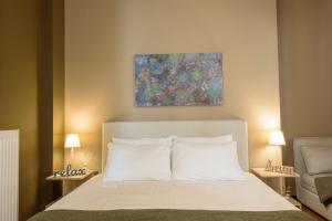 Un dormitorio con una cama con una pintura encima. en Armoniko, en Atenas