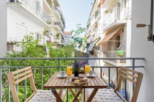 een balkon met een tafel en stoelen bij Armoniko in Athene