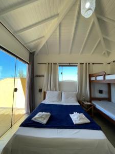 Un dormitorio con una cama y una ventana grande. en Pousada Mar'Tito Forno, en Búzios