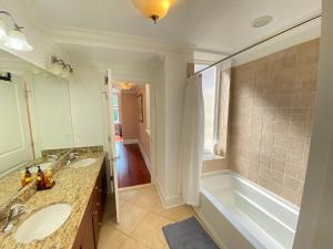 y baño con 2 lavabos y bañera. en Classy Victorian Brownstone Subway Shopping, en Washington