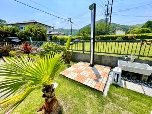 um jardim com um lavatório e uma palmeira em 弓ヶ浜海水浴場徒歩1分! 一棟貸別荘! Yumigahama Beach House & BBQ! em Minamiizu