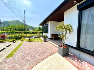 a house with a potted plant in a courtyard at 弓ヶ浜海水浴場徒歩1分! 一棟貸別荘! Yumigahama Beach House & BBQ! in Minamiizu