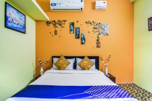 - une chambre avec un grand lit aux murs orange dans l'établissement SPOT ON M R Plaza, à Bhubaneswar