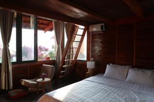 1 dormitorio con cama, escalera y silla en Samma Stay Tam Đảo, en Tam Ðảo