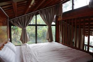 a bedroom with a bed with a large window at Samma Stay Tam Đảo in Tam Ðảo