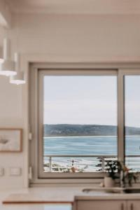 a kitchen window with a view of the ocean at Olga and Alma - The Coastal Retreat in Pambula Beach
