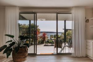 a kitchen with a large sliding glass door with a patio at Olga and Alma - The Coastal Retreat in Pambula Beach