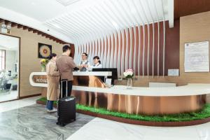 a lobby with people standing at a reception desk at International Hotel in Ulaanbaatar in Ulaanbaatar