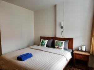 una camera da letto con un letto con una borsa blu sopra di Petit Suncliff Resort a Haad Rin