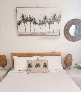 a bedroom with a bed with a framed picture of palm trees at Peninsula Beach Motel in Rosebud