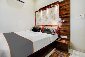 1 dormitorio con 1 cama con cabecero de madera en Hotel Tejesvi, en Jaipur