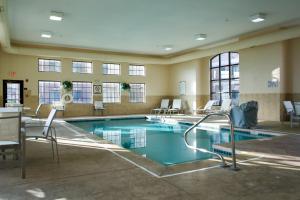 una piscina en un edificio con sillas alrededor en Staybridge Suites Akron-Stow-Cuyahoga Falls, an IHG Hotel, en Stow